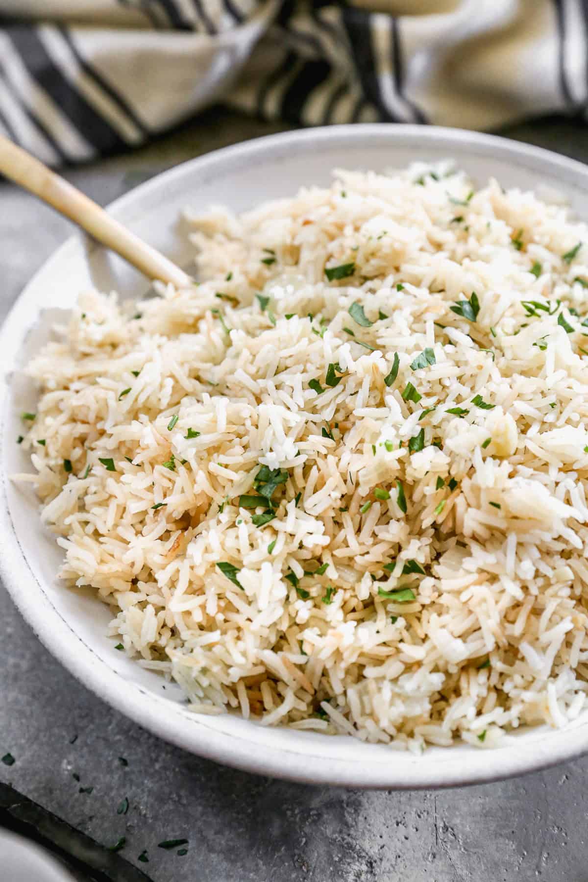 The best Rice Pilaf recipe in a large bowl with chopped parsley stirred in. 