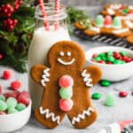 An easy Gingerbread Cookies recipe showing a decorated gingerbread man leaning on a jar of milk.