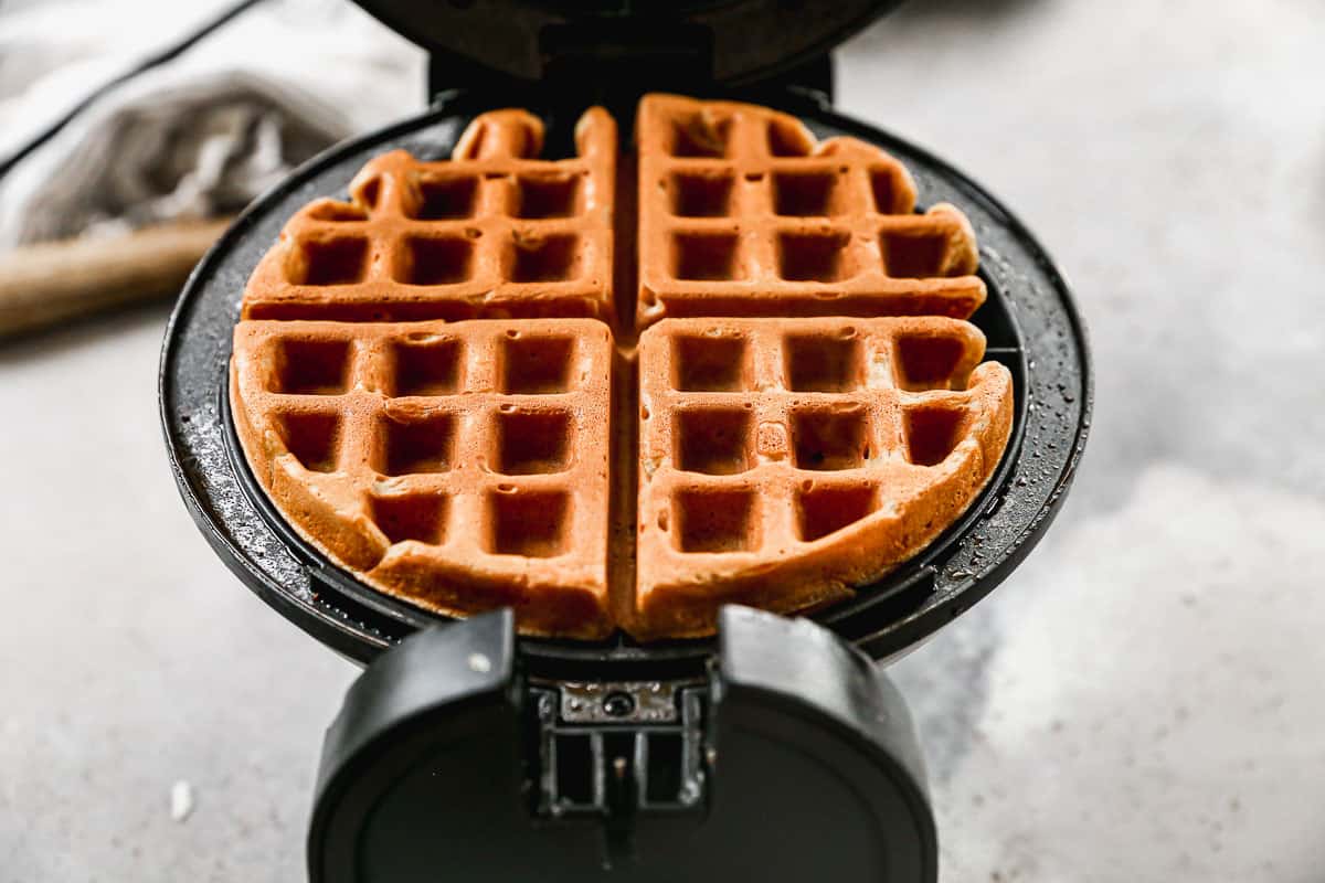 A waffle iron with a fresh homemade Gingerbread Waffle cooked and hot.
