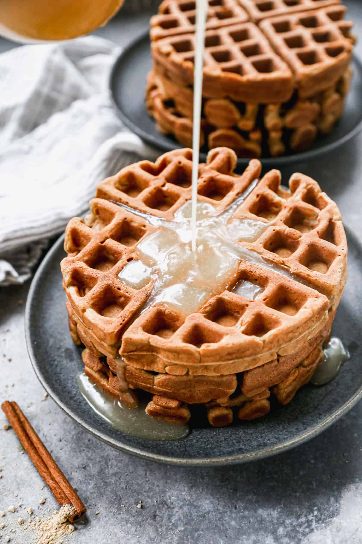 Vanilla syrup being poured on top of the best Gingerbread Waffles.