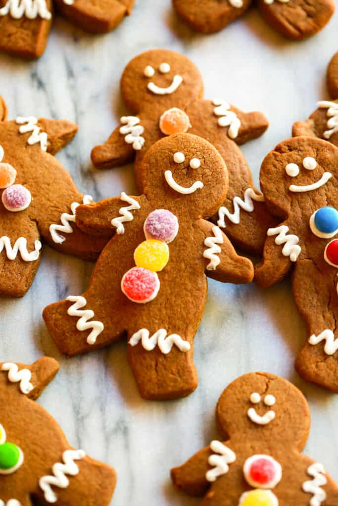 Homemade gingerbread men laying on a marble counter.
