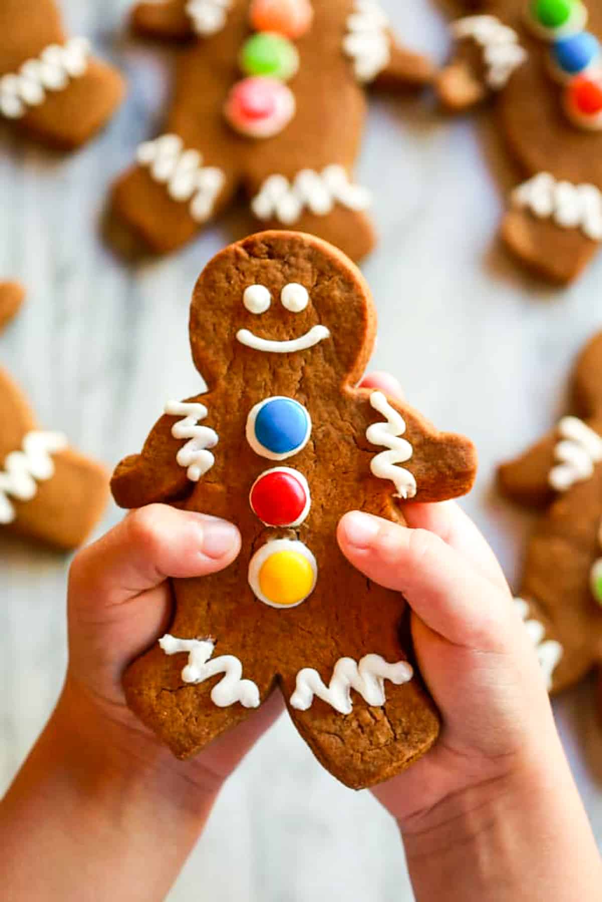A child's hand holding a chewy gingerbread man cookie. 
