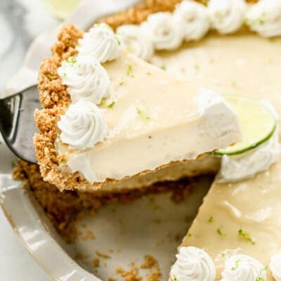 An easy Key Lime Pie recipe with one slice being raised from the pie to serve.