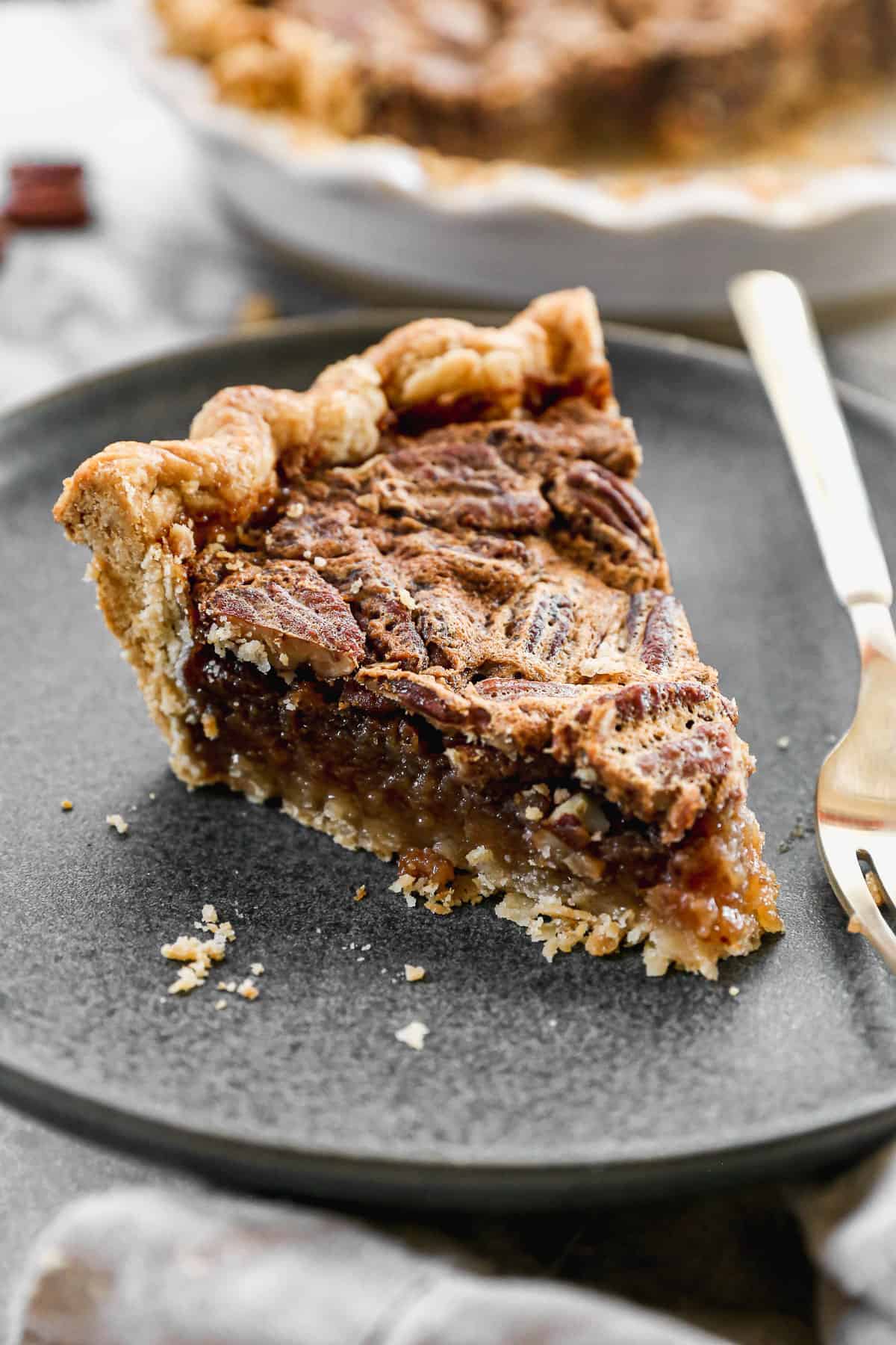 A slice of Pecan Pie on a plate with a fork, ready to enjoy!