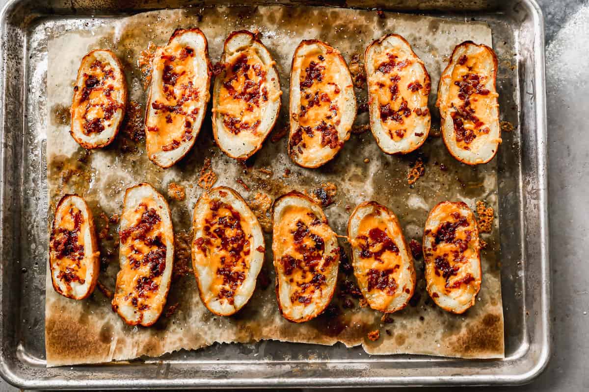 Resep kulit kentang terbaik segar dari oven dengan keju dan bacon, dan siap untuk topping.