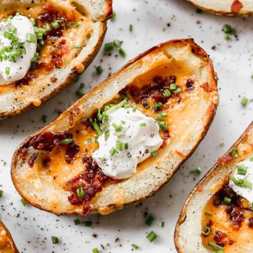 Crispy potato skins loaded with melted cheese, bacon, sour cream, and chives are everyone's favorite appetizer or side dish! Learn how to make potato skins at home!