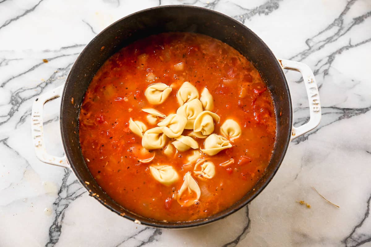 Tortellini ditambahkan ke kaldu sayuran untuk membuat sup tortellini yang mudah.