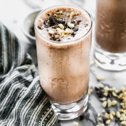 A Chocolate Protein Shake topped with cacoa nibs and rice crispy cereal, ready to enjoy.
