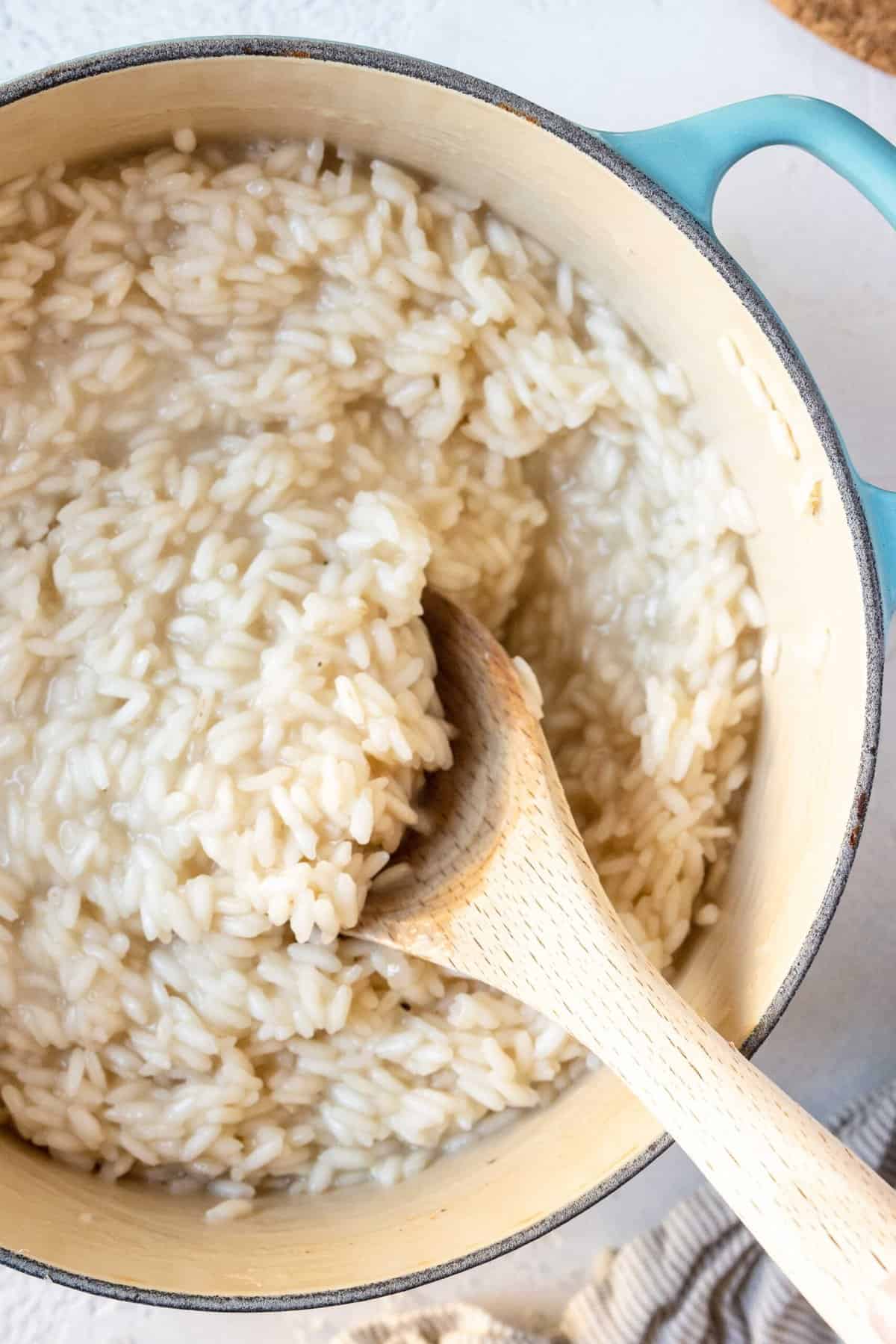 A close-up image of easy homemade risotto with a wooden spoon, ready to serve.