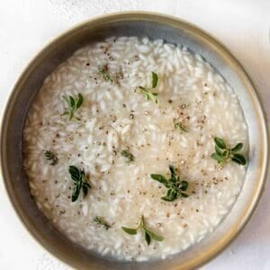 A bowl of classic risotto with fresh herbs on top, ready to enjoy.