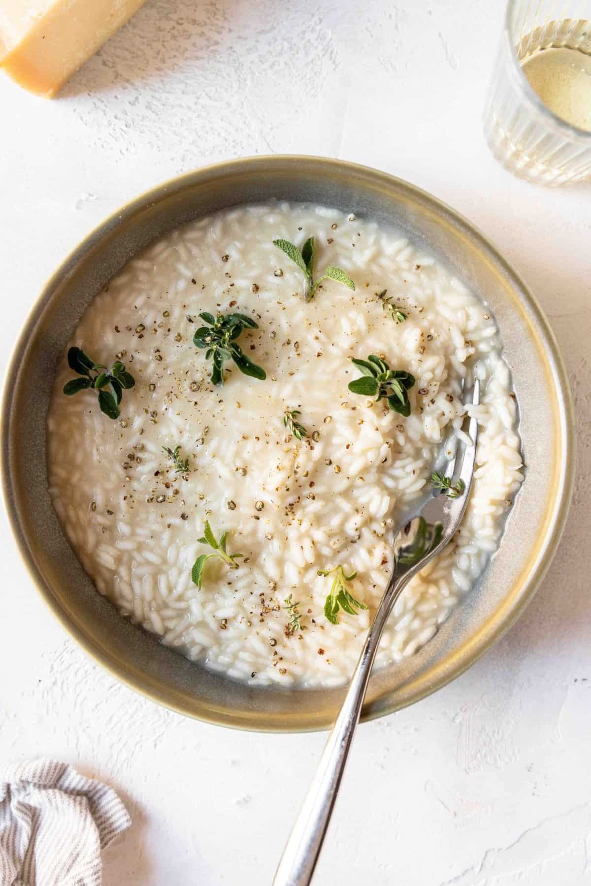 A bowl of homemade risotto topped with sprinkles of fresh herbs.