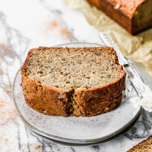 Two thick slices of the best banana bread stacked on a plate, ready to enjoy.
