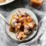 The best Bread Pudding recipe served on a plate with a drizzle of vanilla cream sauce on top.
