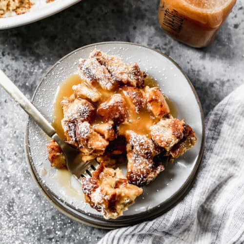 The best Bread Pudding recipe served on a plate with a drizzle of vanilla cream sauce on top.