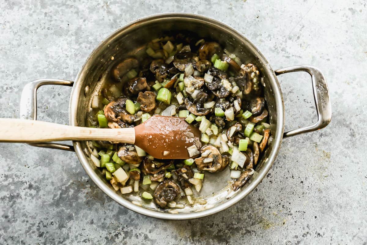 Mushrooms with celery and onion being sautéed in butter. 