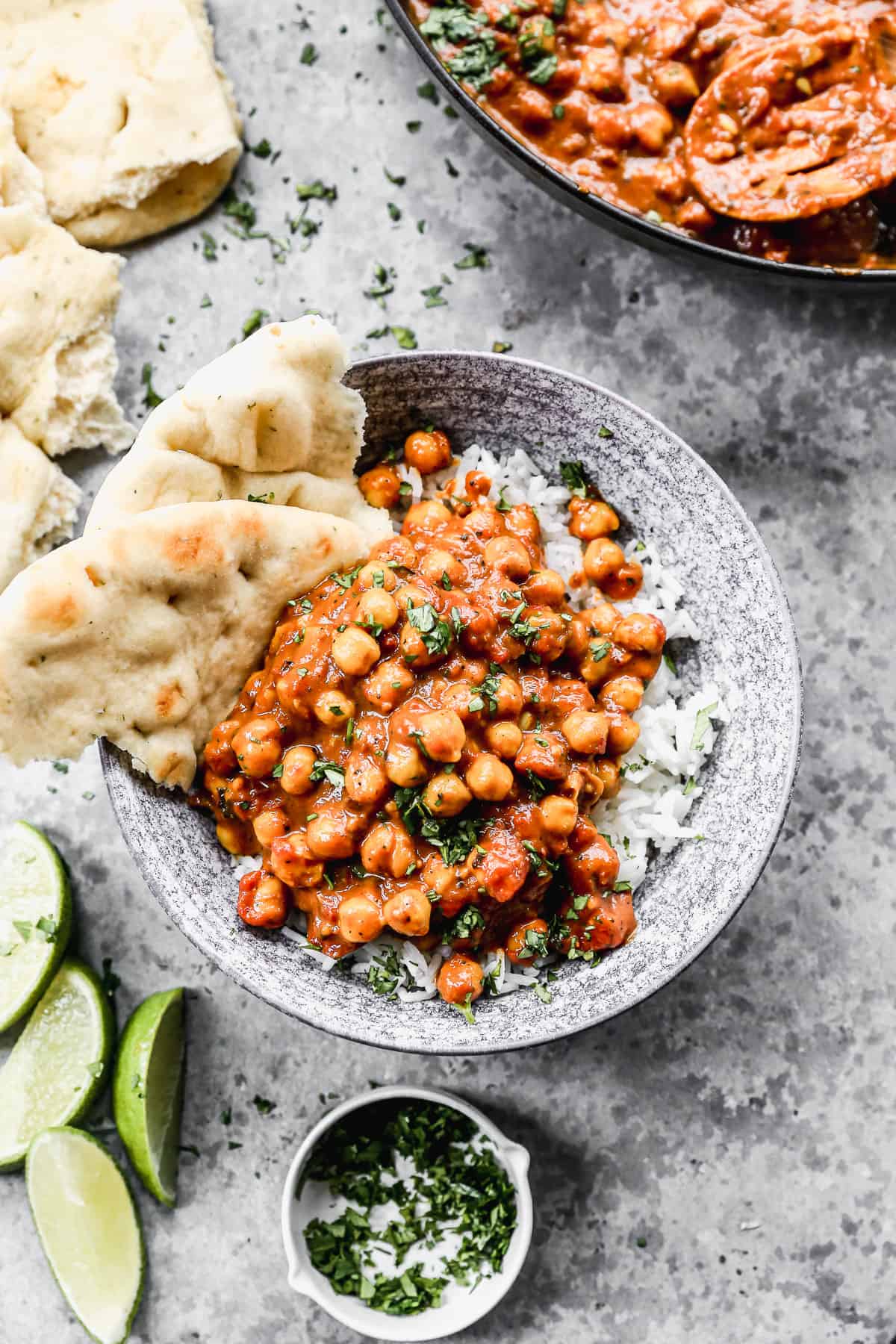 Easy Chickpea Curry in a bowl on top of a bed of white rice and served with naan on the side.