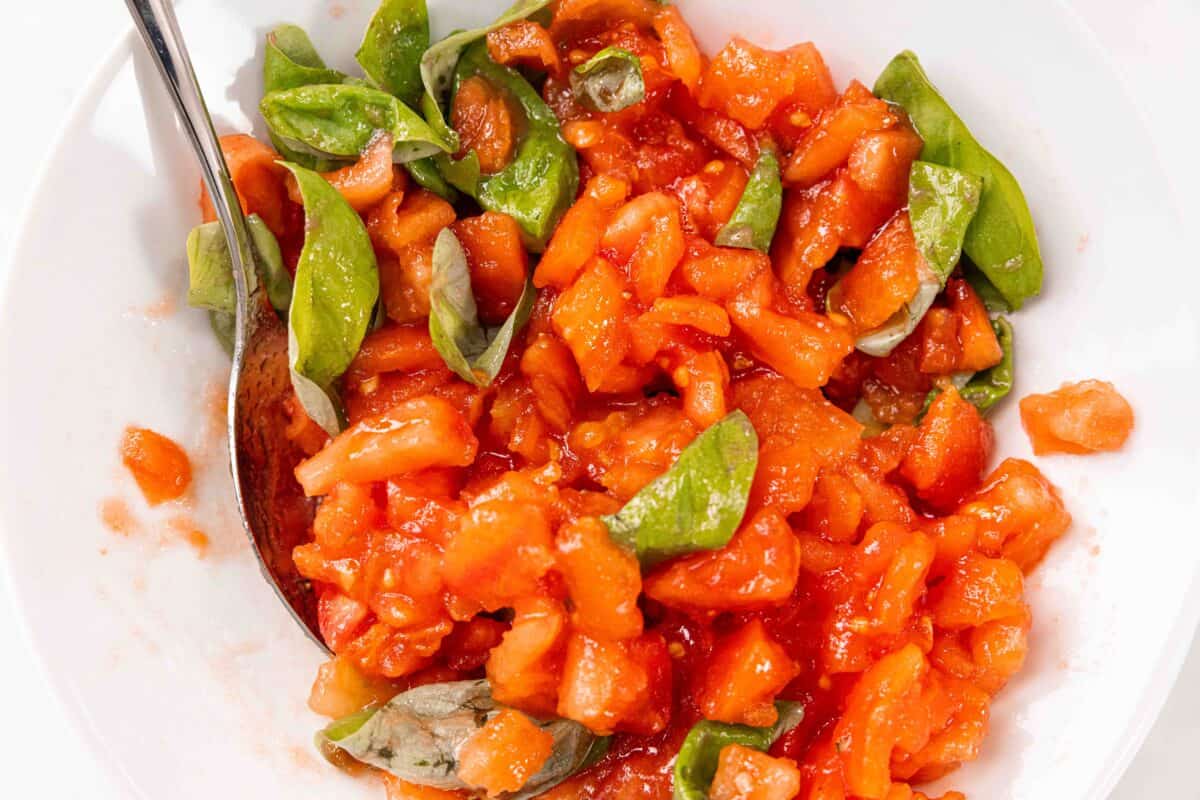 Semangkuk campuran tomat dan kemangi untuk bruschetta buatan sendiri.