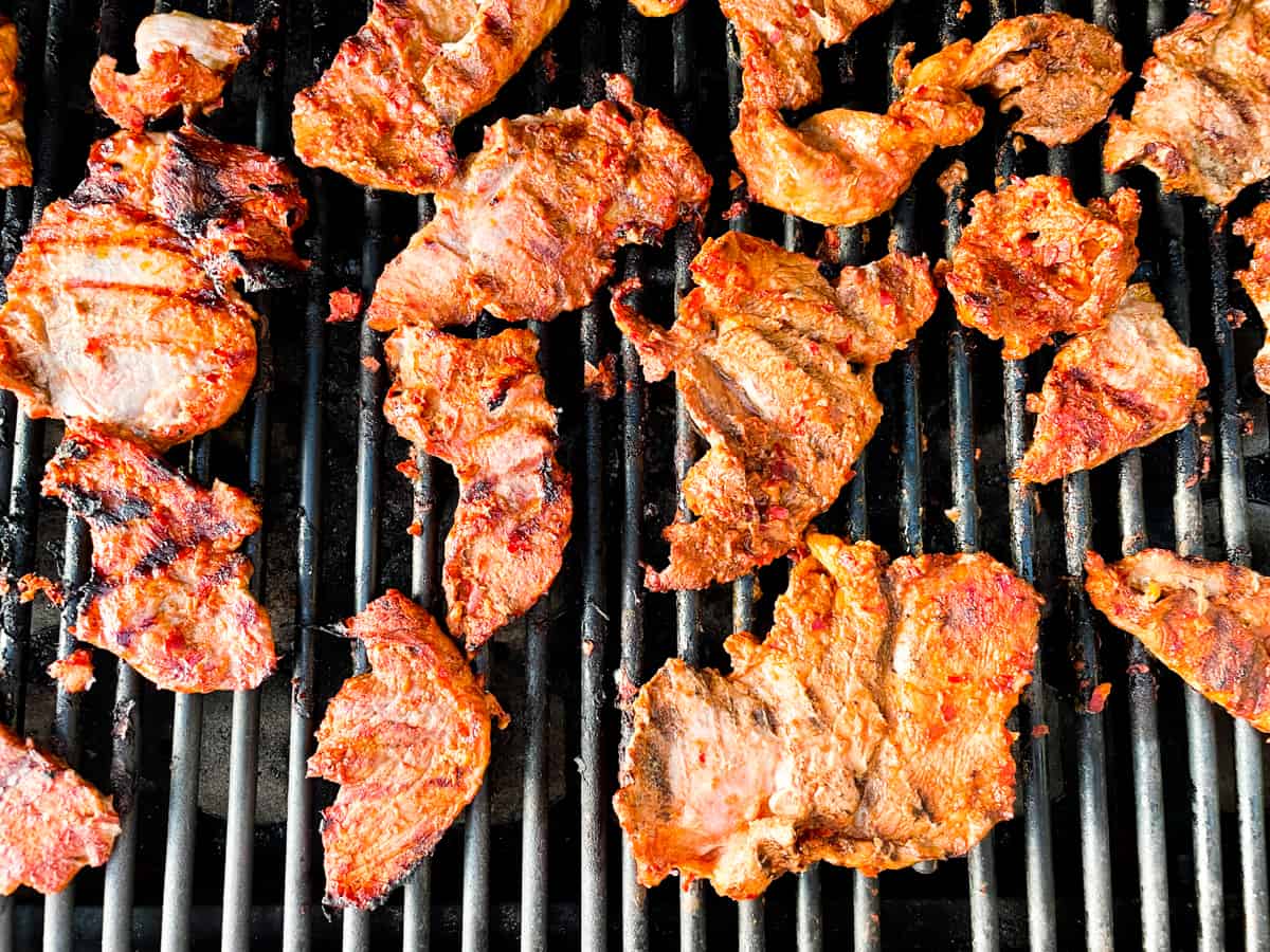 Slices of pork on the grill to make Tacos Al Pastor.