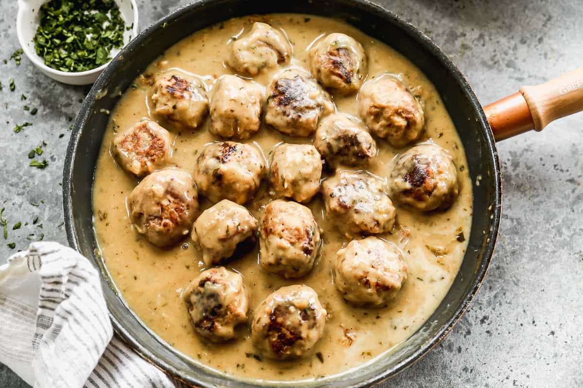 Green Curry Meatballs in a non-stick pan, ready to serve with rice.