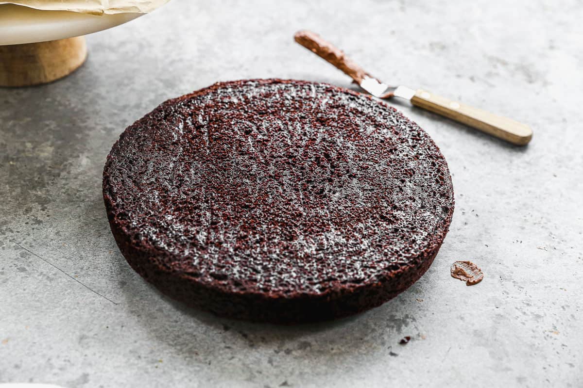A baked chocolate cake round cooled and removed from the pan, ready to frost.