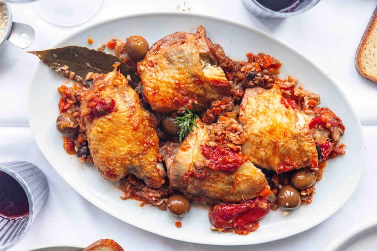 A white platter with Chicken Cacciatore on it, ready to be served.