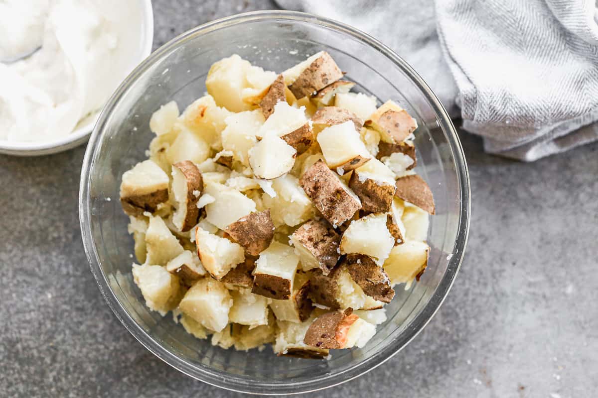 Baked potatoes cut into bite size chunks and placed into a bowl for easy Baked Potato Salad.