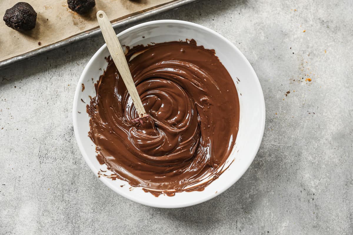 A white bowl with melted chocolate, ready to dip the best Brownie Truffles.