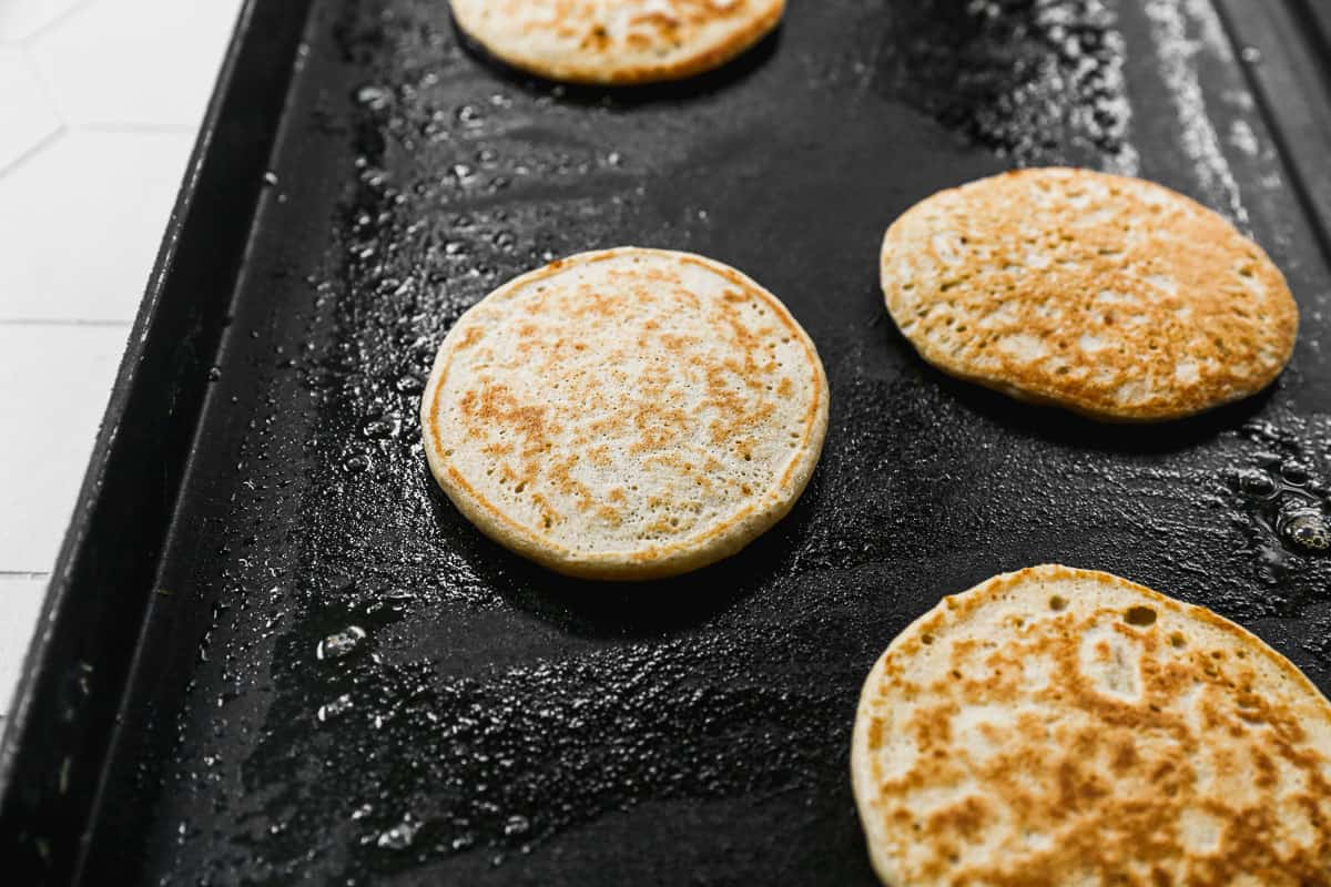 Cottage Cheese Pancakes being cooked on a griddle until golden brown.