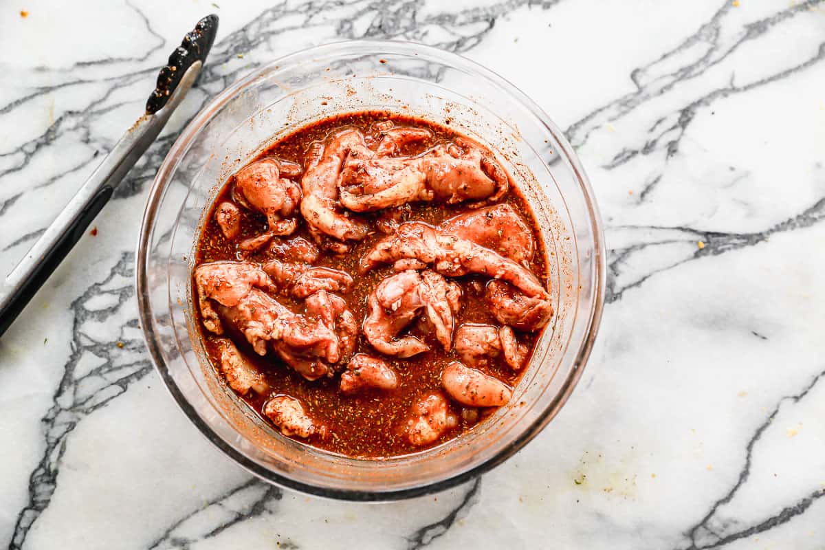 Chicken Thighs marinating in a bowl of marinade for the best Chicken Street Tacos recipe. 