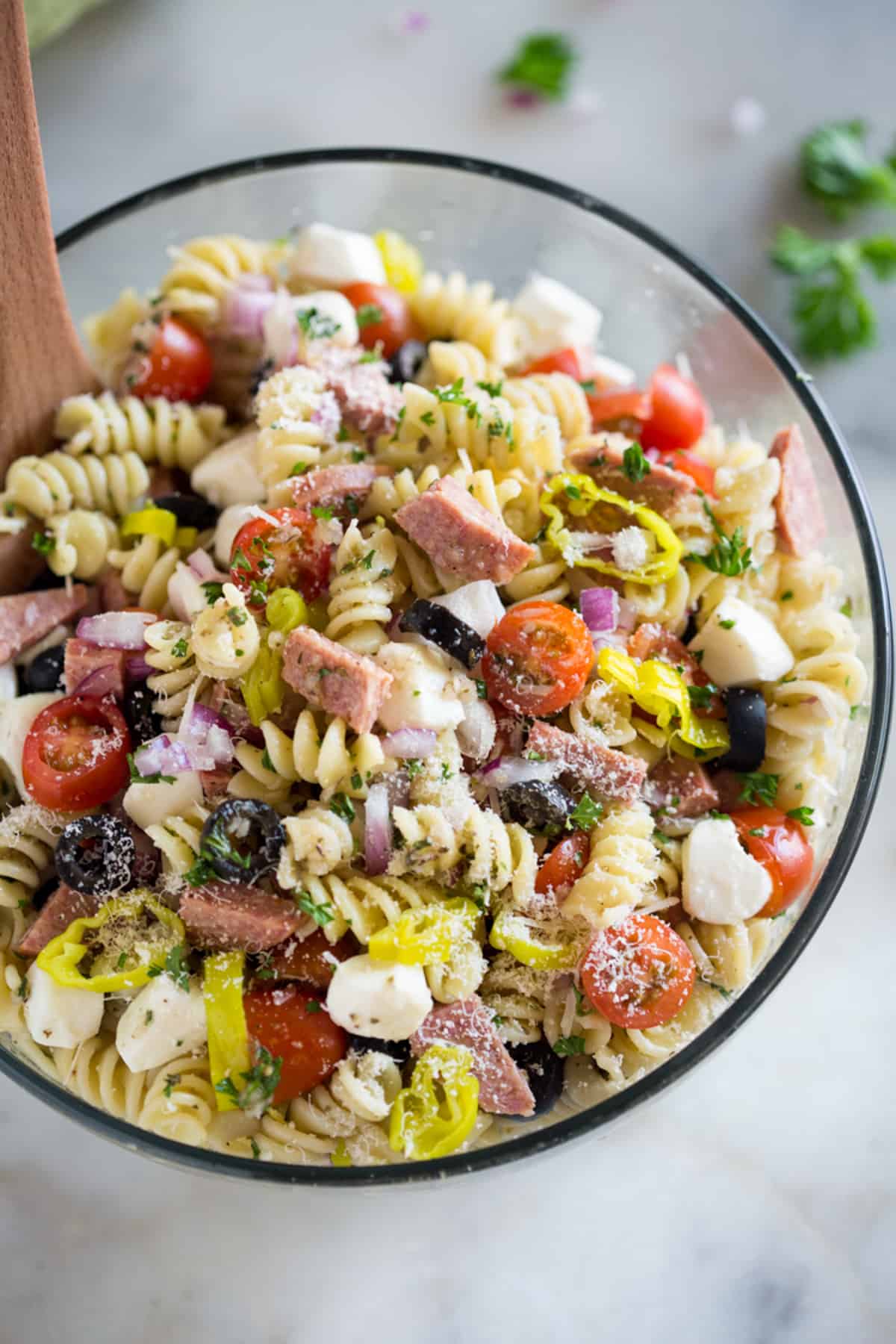 A glass bowl filled with fresh Italian Pasta Salad.