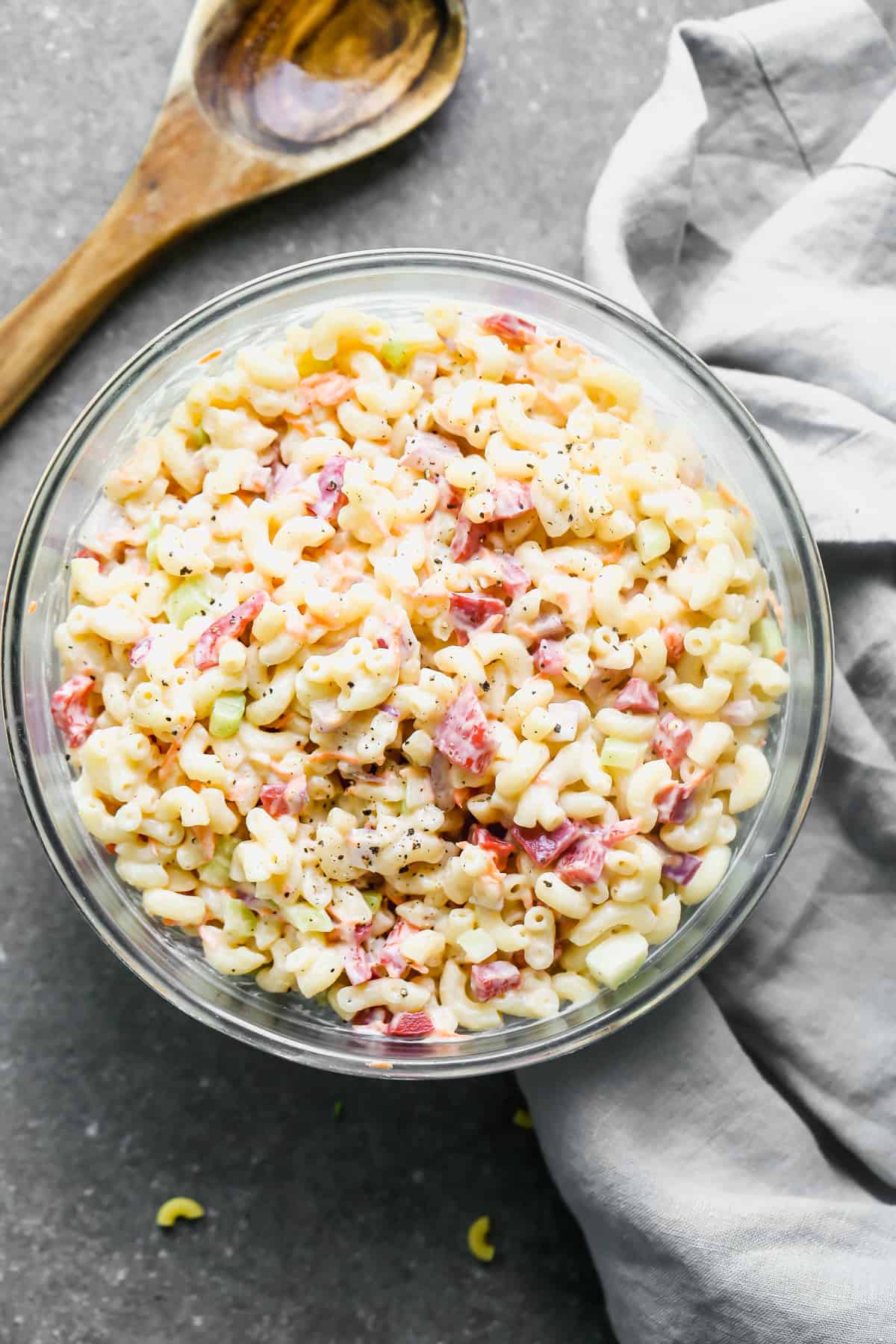A glass bowl filled with Classic Macaroni Salad, ready to serve.