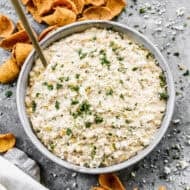 An easy Mexican Street Corn Dip recipe in a large bowl with frito chips scattered around it, ready to enjoy.