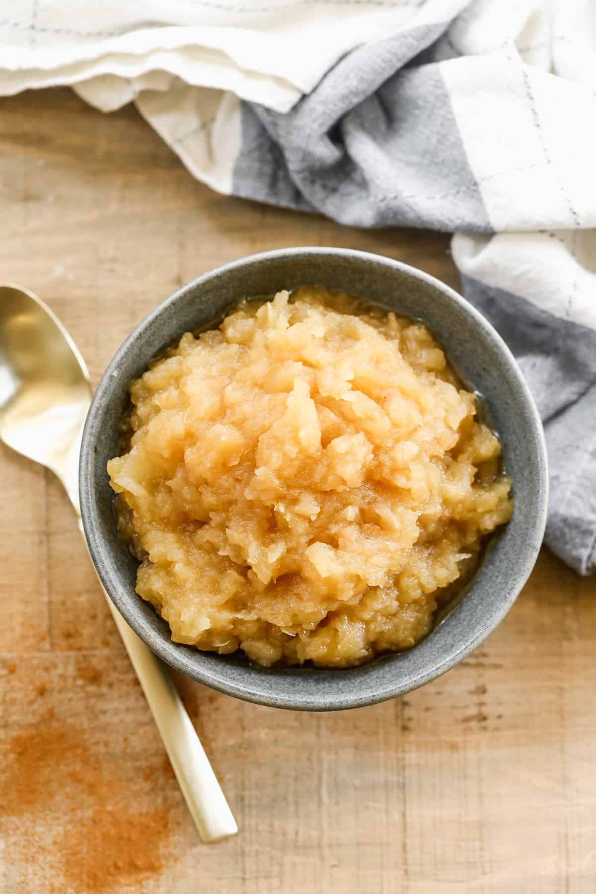 A bowl of homemade applesauce with a spoon, ready to enjoy.