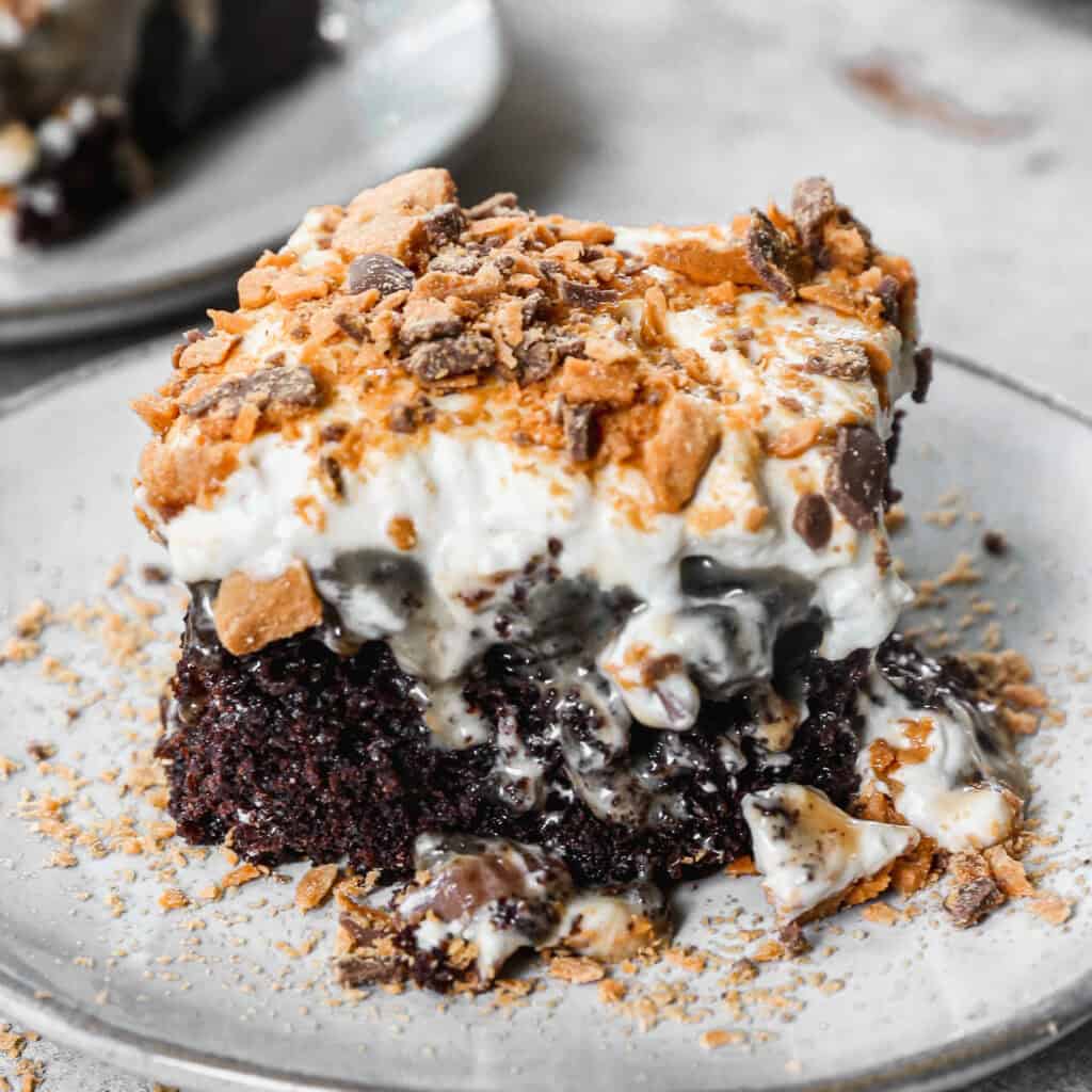 This Butterfinger Candy Bar Cake has a chocolate cake base poked with holes and drizzled with caramel and sweetened condensed milk. We tie it all together with a peanut butter buttercream and chopped butterfinger on top. It's so dreamy but actually easy to make!