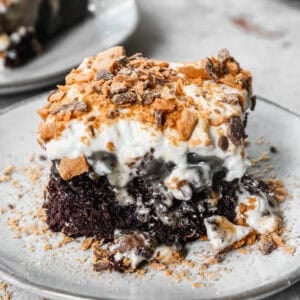 This Butterfinger Candy Bar Cake has a chocolate cake base poked with holes and drizzled with caramel and sweetened condensed milk. We tie it all together with a peanut butter buttercream and chopped butterfinger on top. It's so dreamy but actually easy to make!