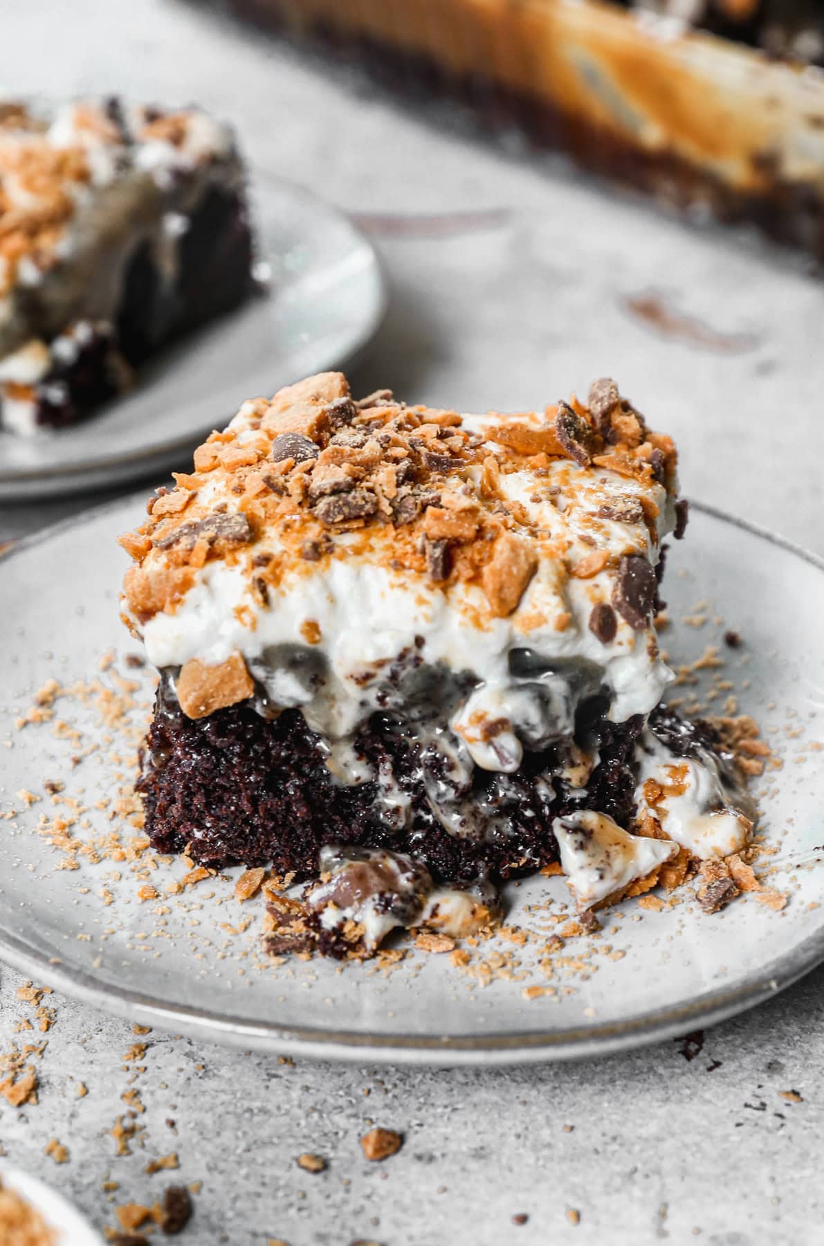 This Butterfinger Candy Bar Cake has a chocolate cake base poked with holes and drizzled with caramel and sweetened condensed milk. We tie it all together with a peanut butter buttercream and chopped butterfinger on top. It's so dreamy but actually easy to make!