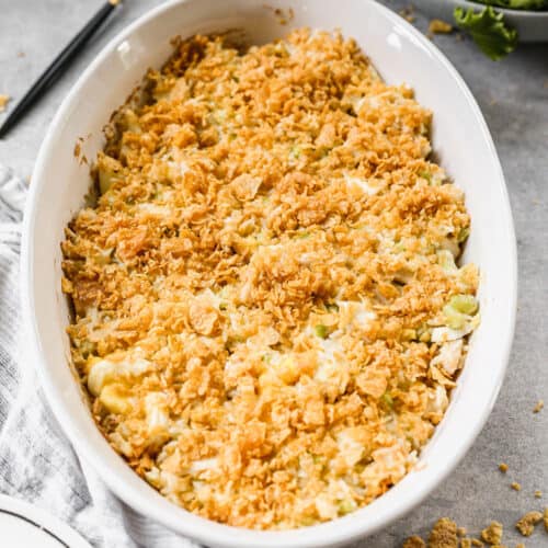 A white oval baking dish filled with an Easy Chicken Casserole recipe, topped with a crunchy cornflake topping.
