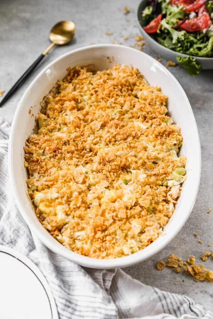 A white oval baking dish filled with an Easy Chicken Casserole recipe, topped with a crunchy cornflake topping.