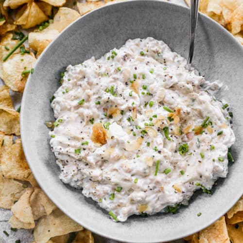 The best French Onion Dip recipe in a bowl, ready to be served with potato chips.
