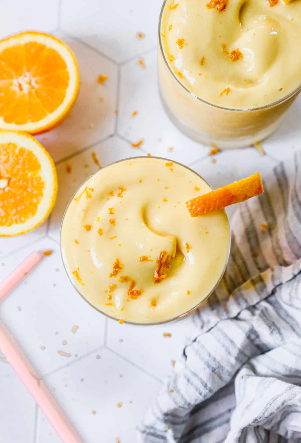 The best Orange Julius recipe in a glass topped with orange zest and an orange slice, ready to enjoy.
