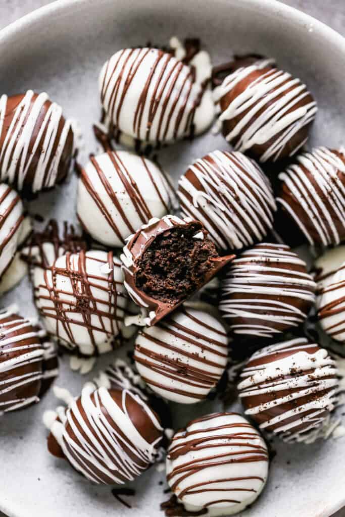 Oreo Balls on a plate, with a bite taken from one.