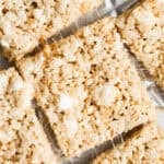 The best rice krispie treats recipe on a piece of parchment paper and cut into squares.