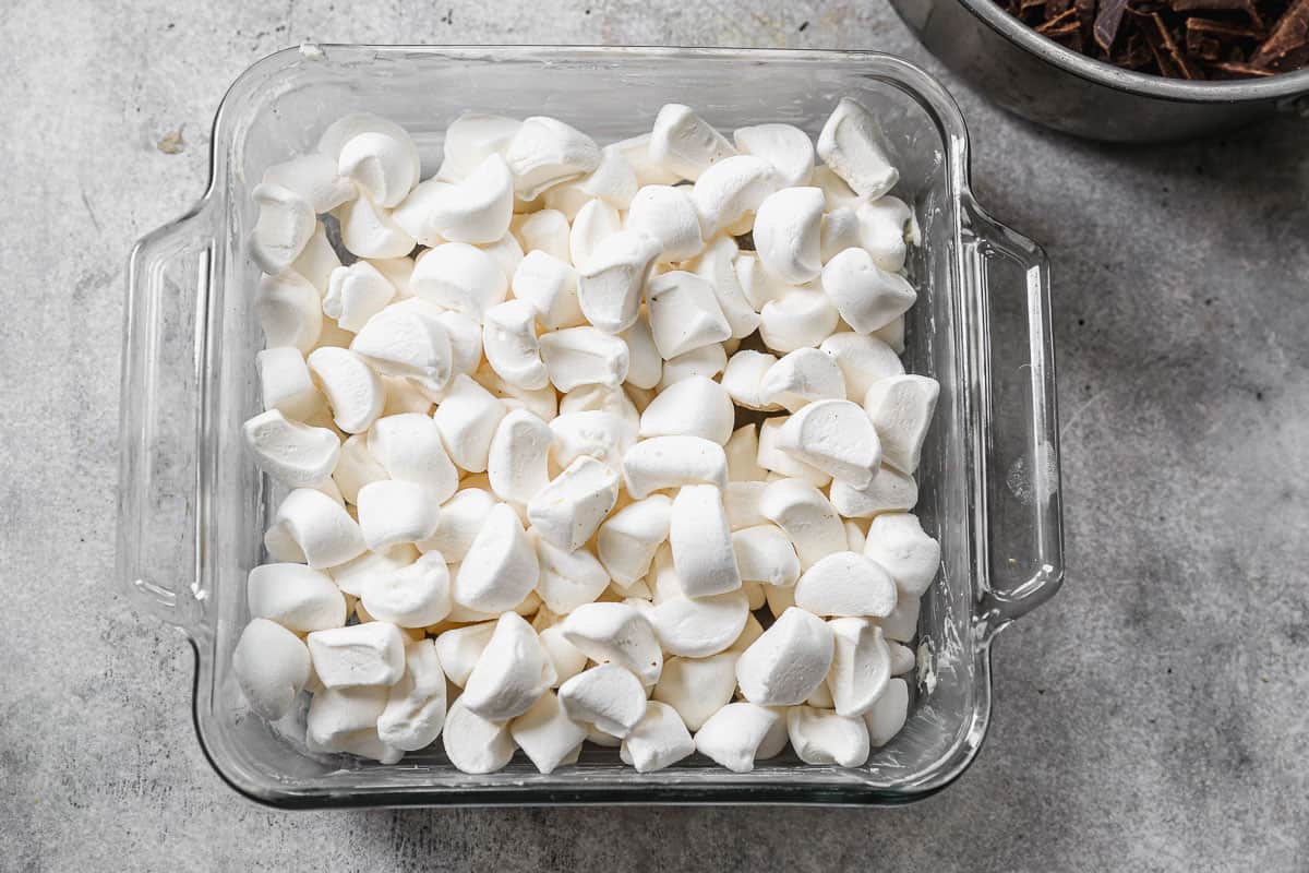A 9x13 glass dish filled with marshmallows cut into fourths for rocky road fudge.