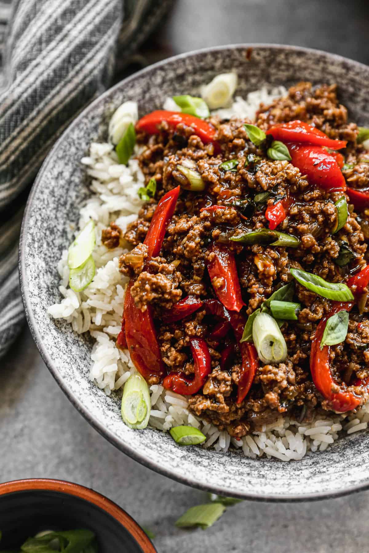 A close up image of an authentic Thai Basil Beef recipe with chopped green onions on top.