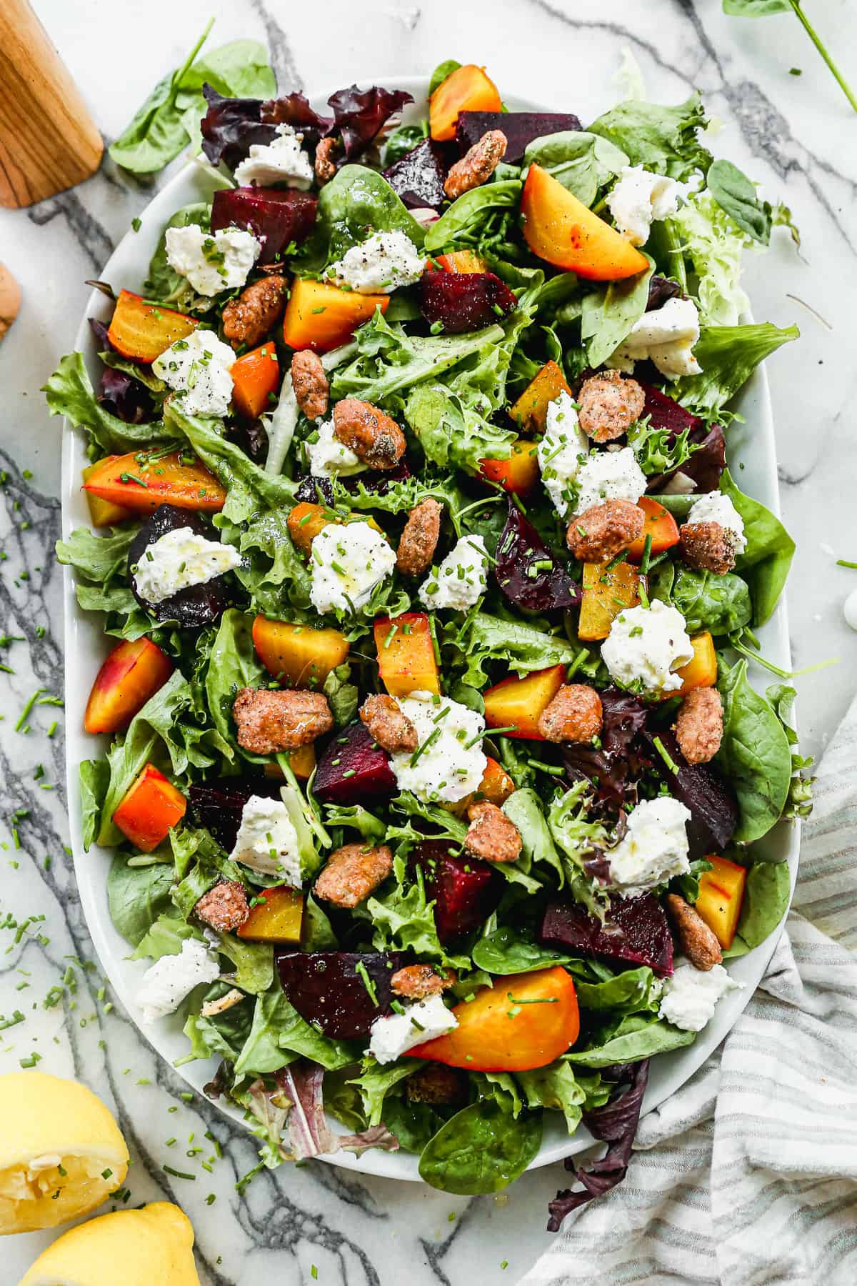 A roasted Beet Salad on a bed of mixed greens with beets, walnuts, and whipped goat cheese.