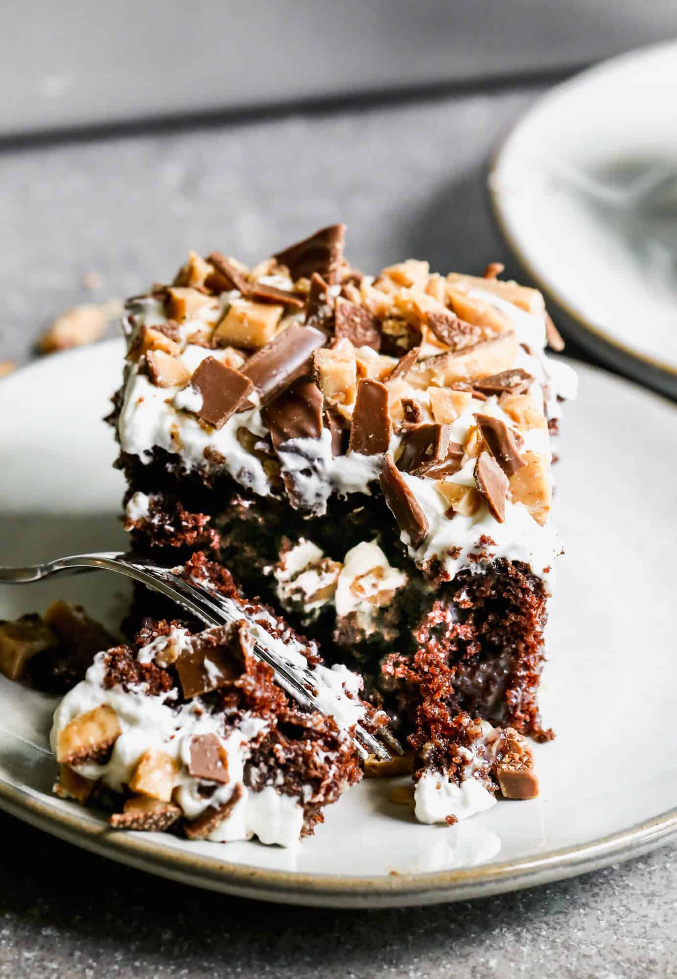 This easy Better Than Sex Cake recipe is rich, moist, and delicious topped with whipped cream and crunchy heath bar pieces. It's the perfect cake for any party!