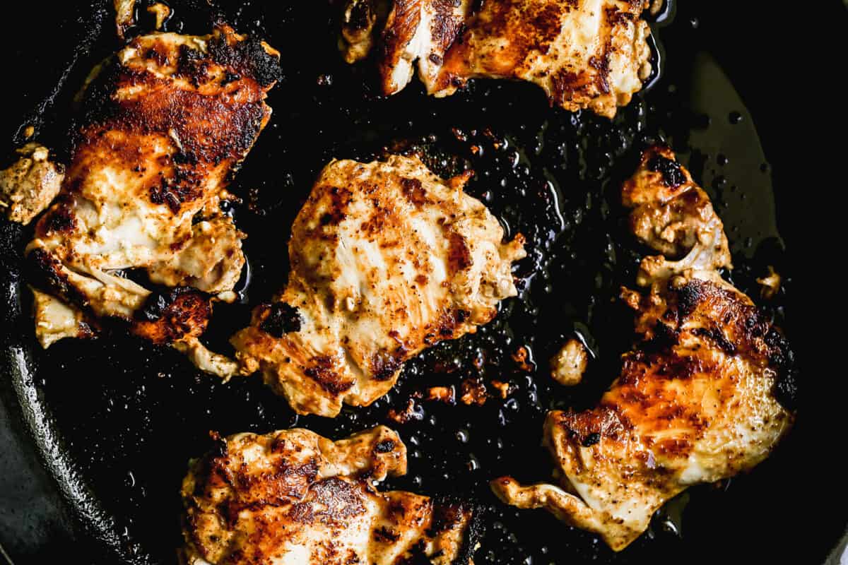 Chicken cooking in a cast iron pan for the best Chicken Tikka Masala recipe.