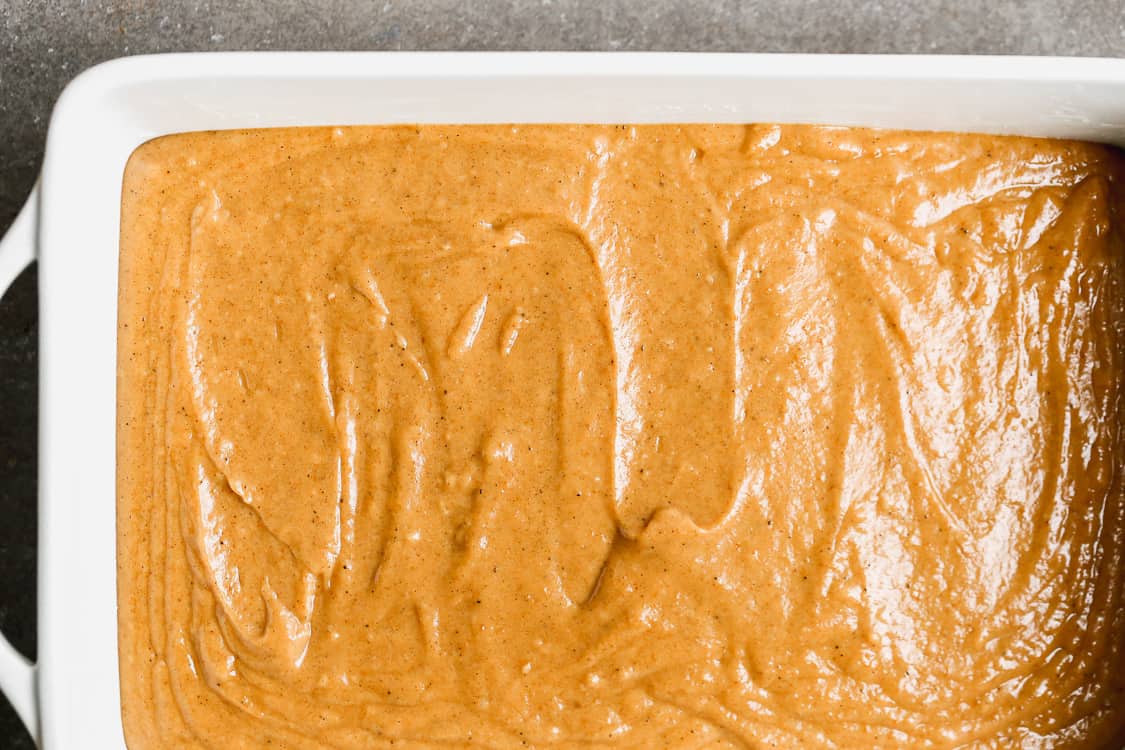 Easy pumpkin cake batter poured into a white 9x13 baking dish.