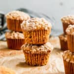 Two easy Pumpkin Cream Cheese Muffins with streusel stacked on top of each other.