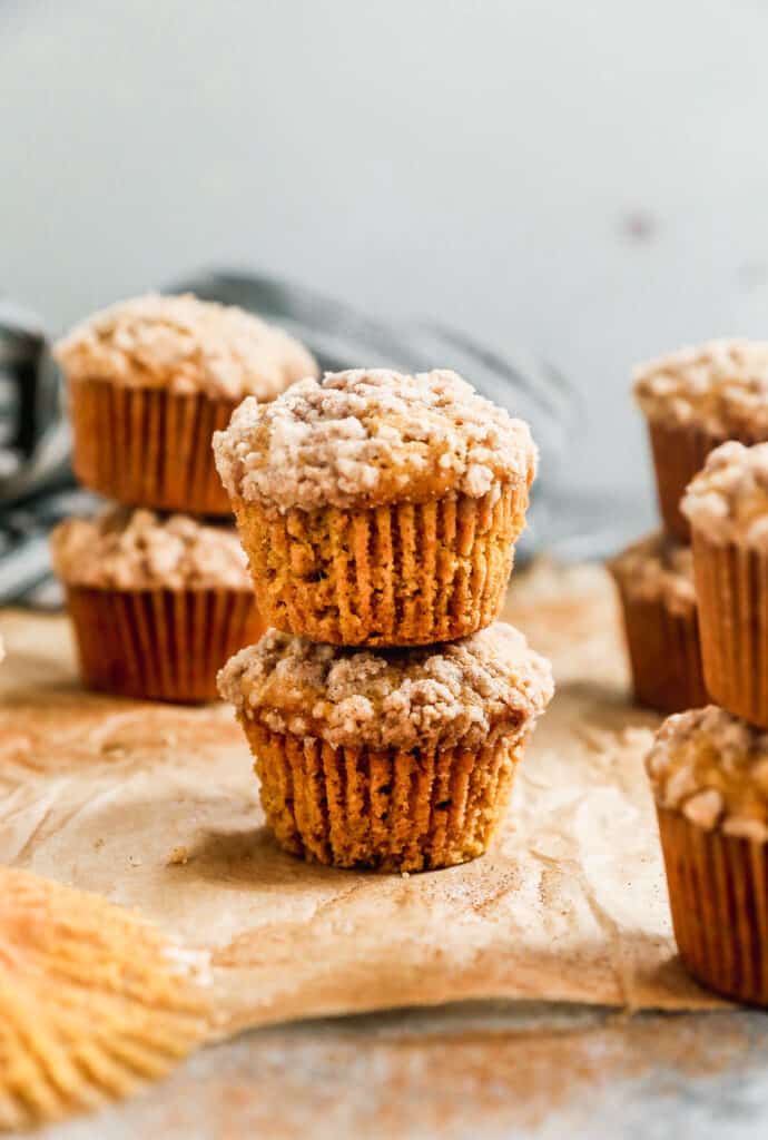 Two easy Pumpkin Cream Cheese Muffins with streusel stacked on top of each other.